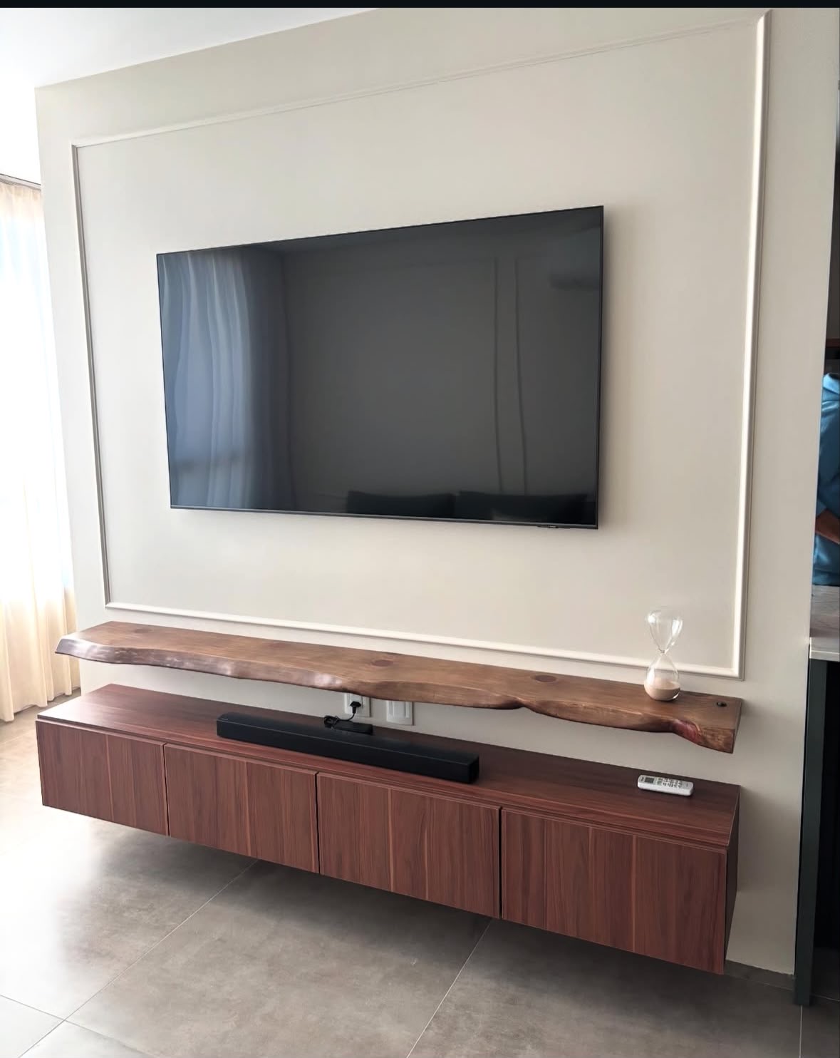 Painel claro com moldura e rack suspenso amadeirado com prateleira